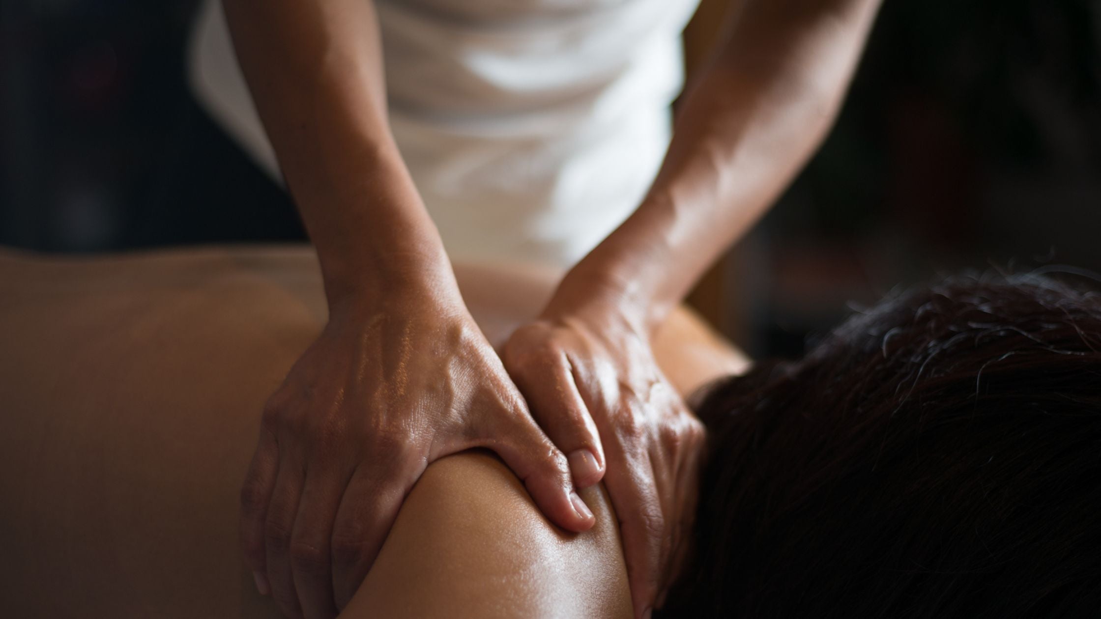 Lady giving someone a massage with CBD oil.