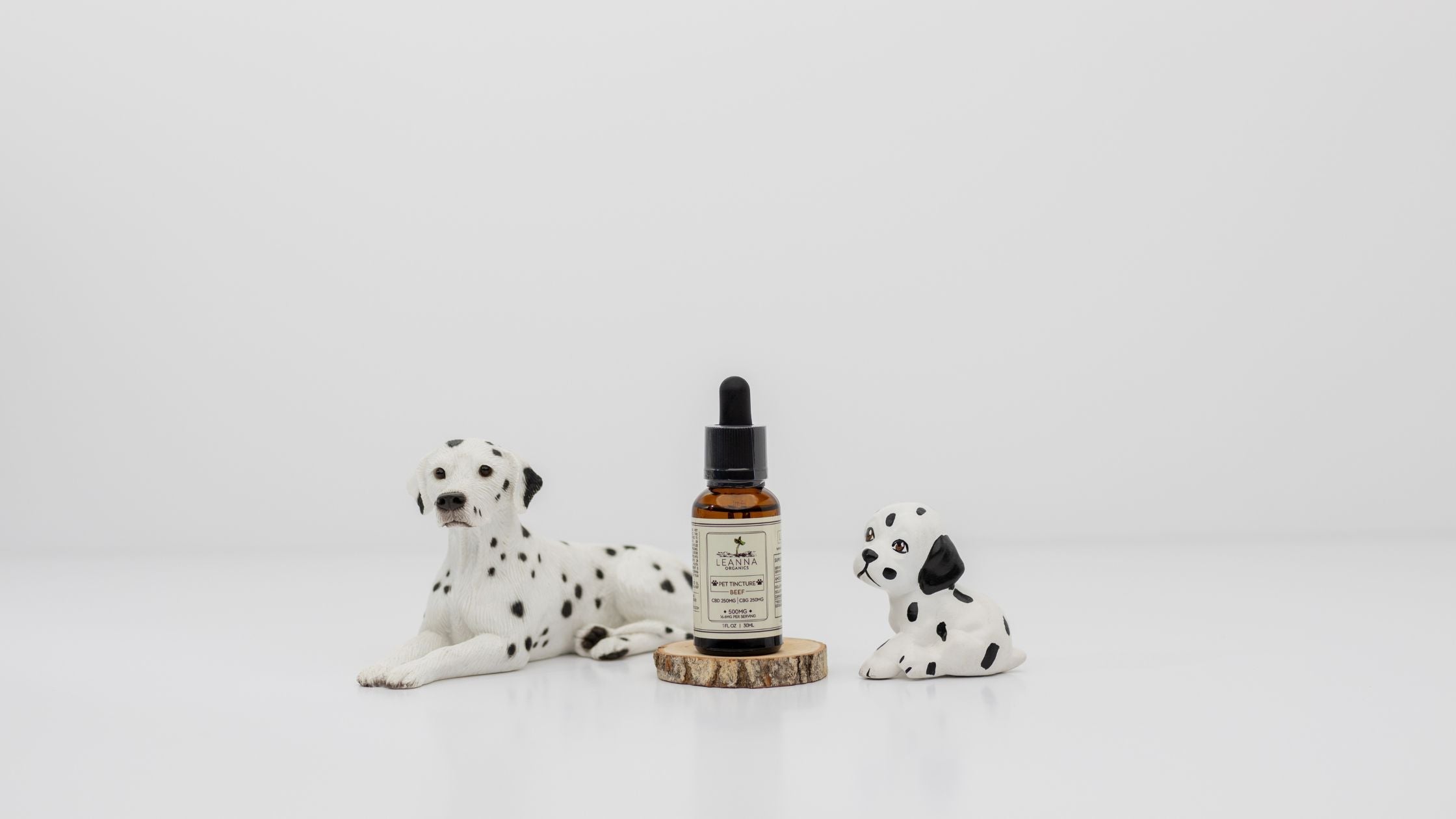 Leanna Organics CBD oil for pets next to pet statues