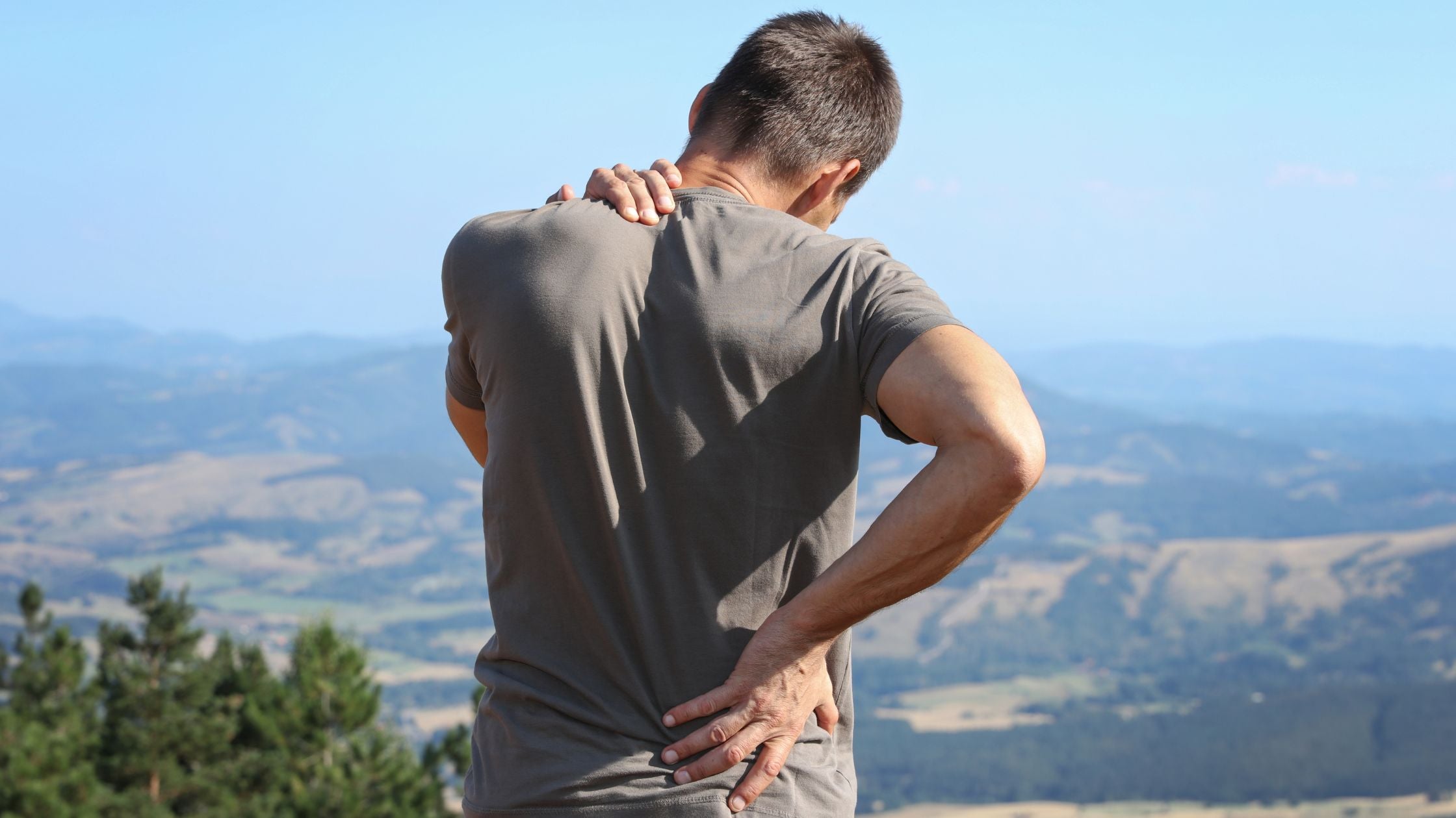Man holding his shoulder and back in pain.