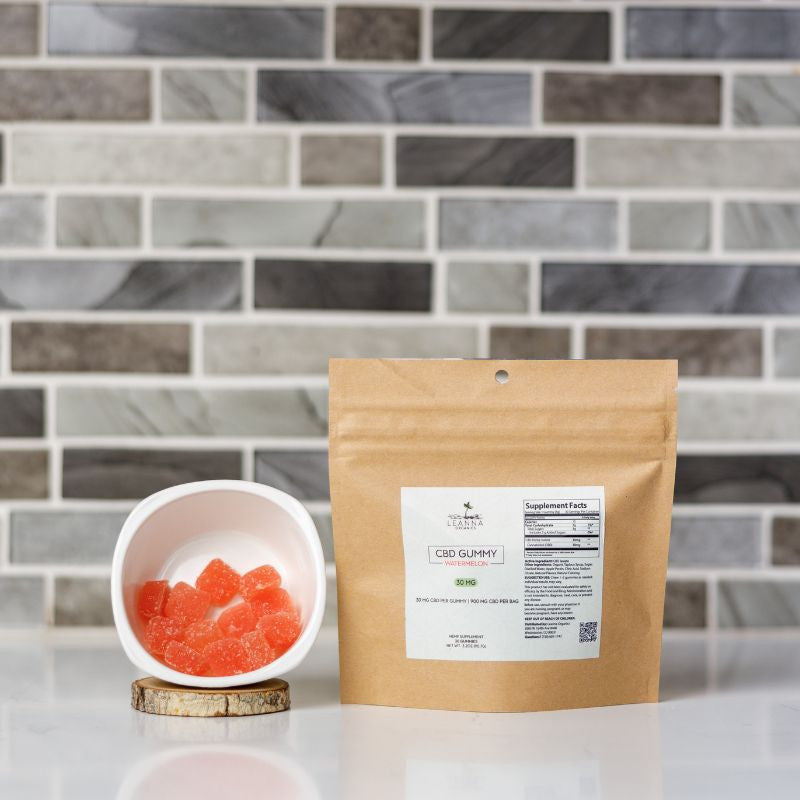 CBD gummy package with a bowl of gummies on a tiled surface